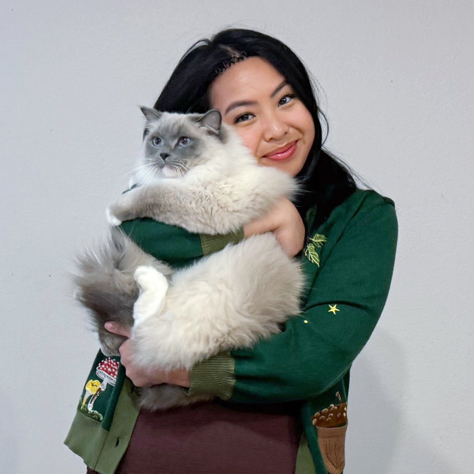 Happy cat parent holding a tabby cat