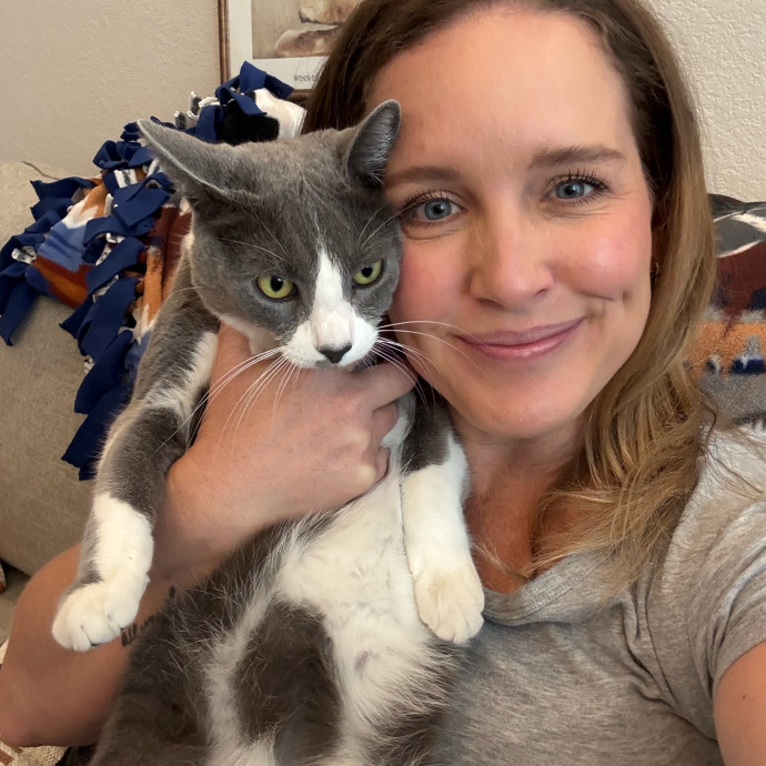 Happy cat parent holding a tabby cat